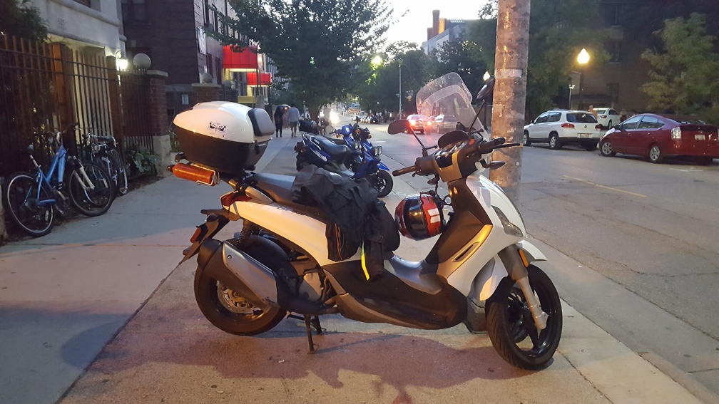 Big scooter in front of smaller scooters. Also only scooter (and rider) I ever saw wearing stuff like a helmet.