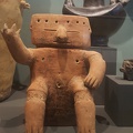 Seated Figure with Ritual Ornamentation in front of Effigy Urn with Bat God Motif