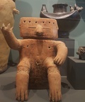 Seated Figure with Ritual Ornamentation in front of Effigy Urn with Bat God Motif